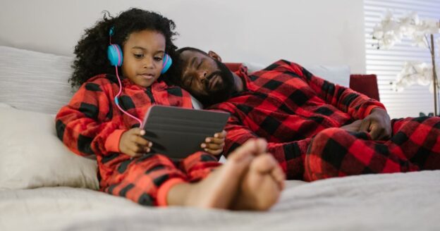 Dad sleeping while daughter plays