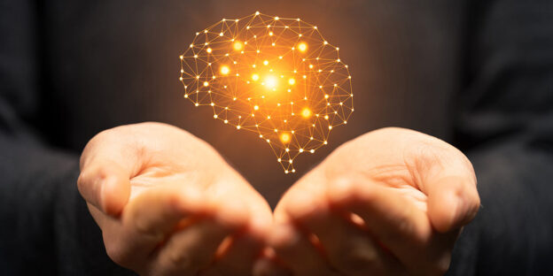 hands holding illuminated brain